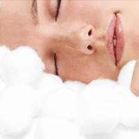 Woman's head laying and resting on cotton balls